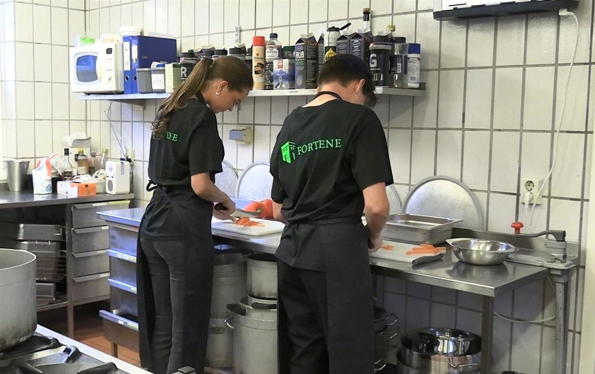 Gutt og jente på restaurantkjøkken. Foto. - Klikk for stort bilde